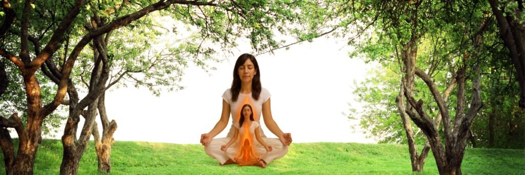 A woman meditates cross-legged with eyes closed, wearing white clothing. A glowing orange flame-like spiral rises from her pelvis to her crown, symbolizing the awakening of Kundalini energy. The forest background and peaceful expression convey balance, sensuality, and inner transformation.